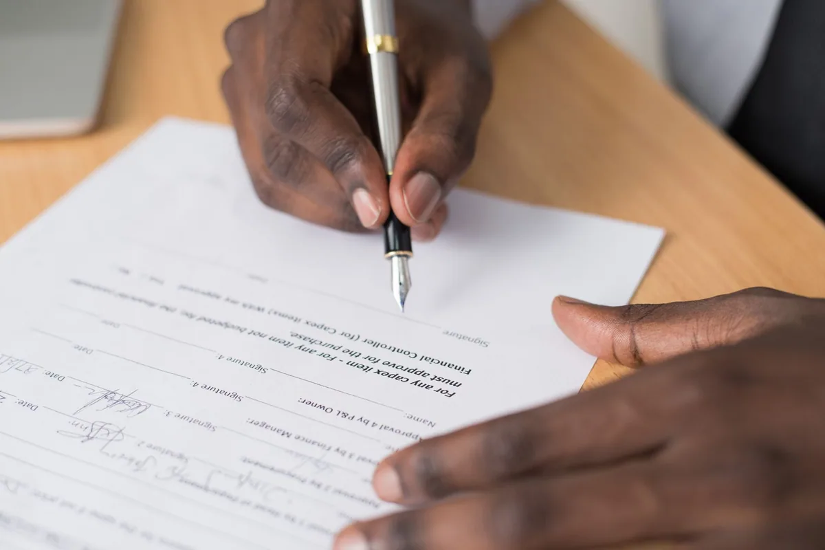 Mesa de notaría con escritura de compraventa y bolígrafo